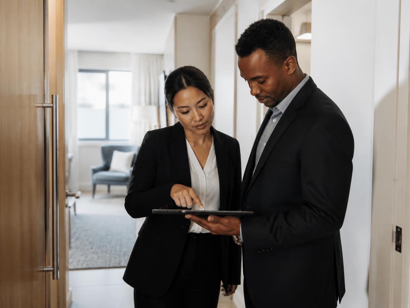 Two hospitality operations professionals reviewing a property checklist inside an upscale residence